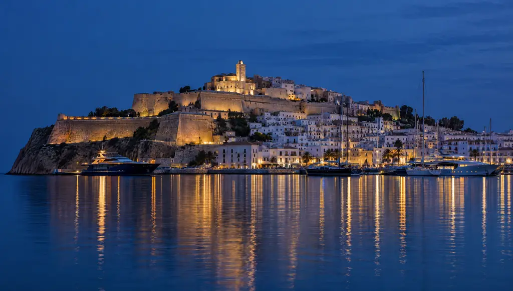 Dalt Vila iluminada desde el agua a la hora azul
