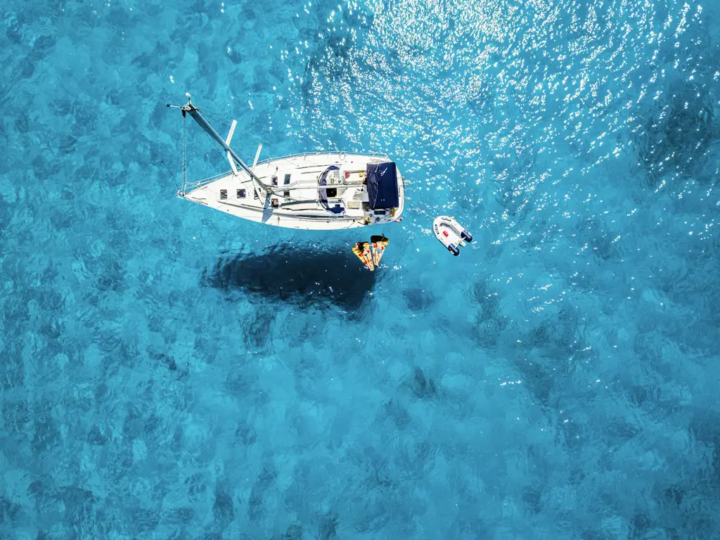 Catamarán fondeado en agua turquesa, vista aérea